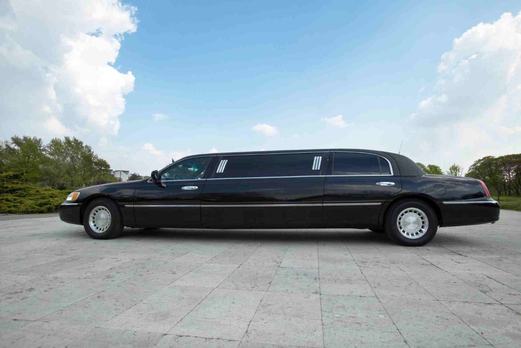 A black limousine parked elegantly on the street, showcasing its sleek design and luxurious presence.