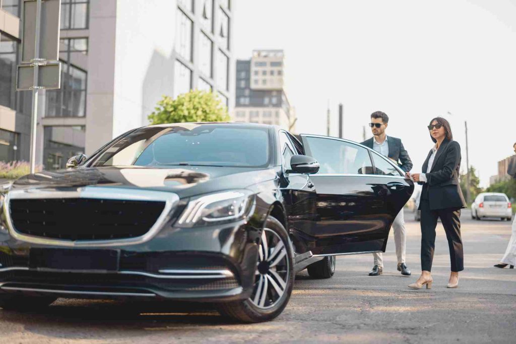 A woman exits a black Mercedes SUV, showcasing elegance and sophistication in her movement.